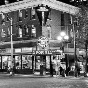 a black & white photo of a city corner building 3 stories tall