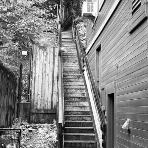 black & white photo of an alley that leads to tall staircase